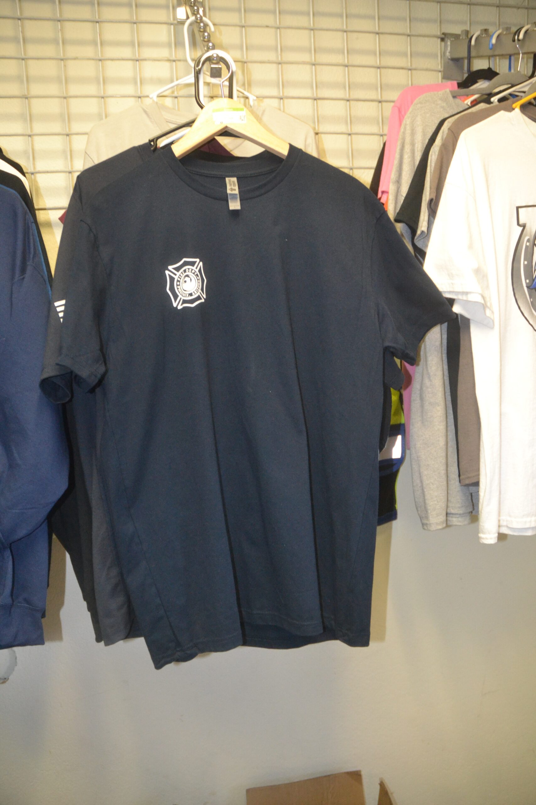 Navy Phoenix Fire Department custom shirt displayed on a hanger at Phoenix Custom Tees.<br />

