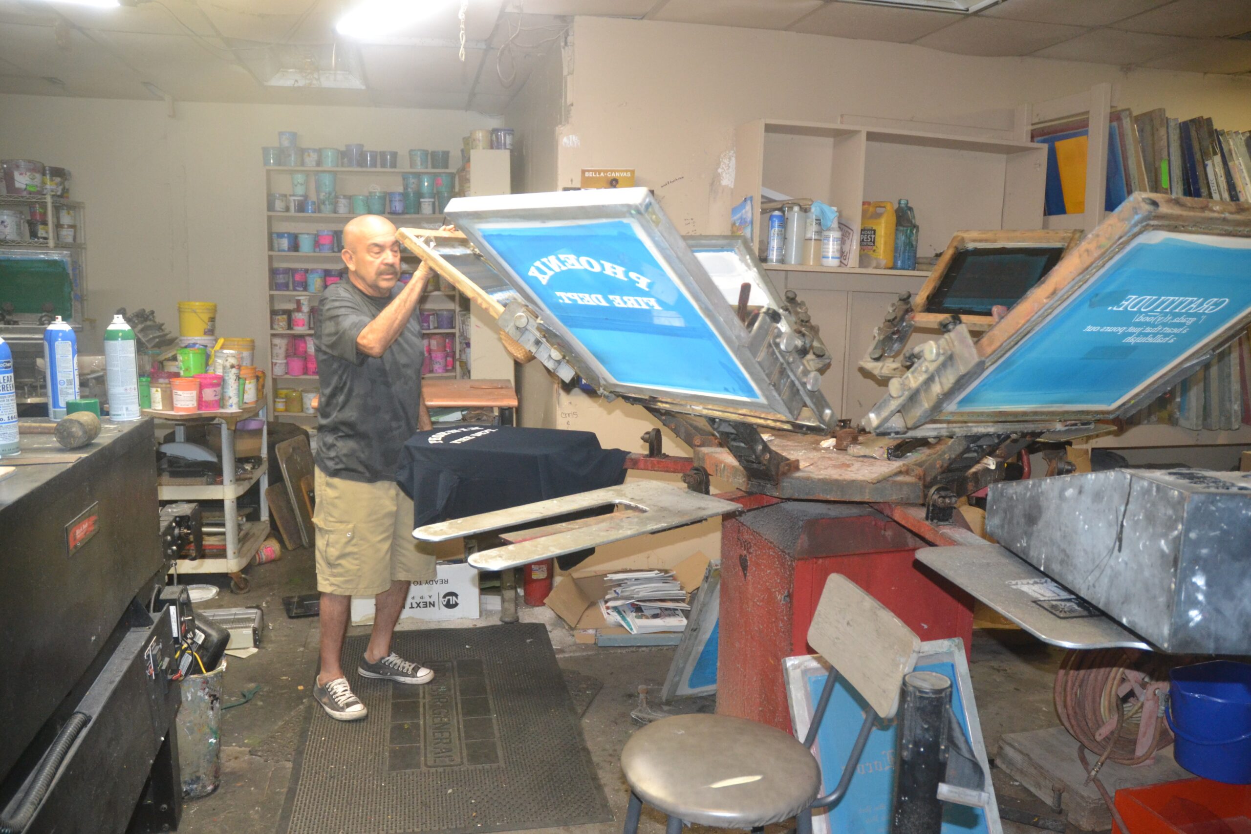 Screen printing equipment inside the Phoenix Custom Tees custom apparel shop.